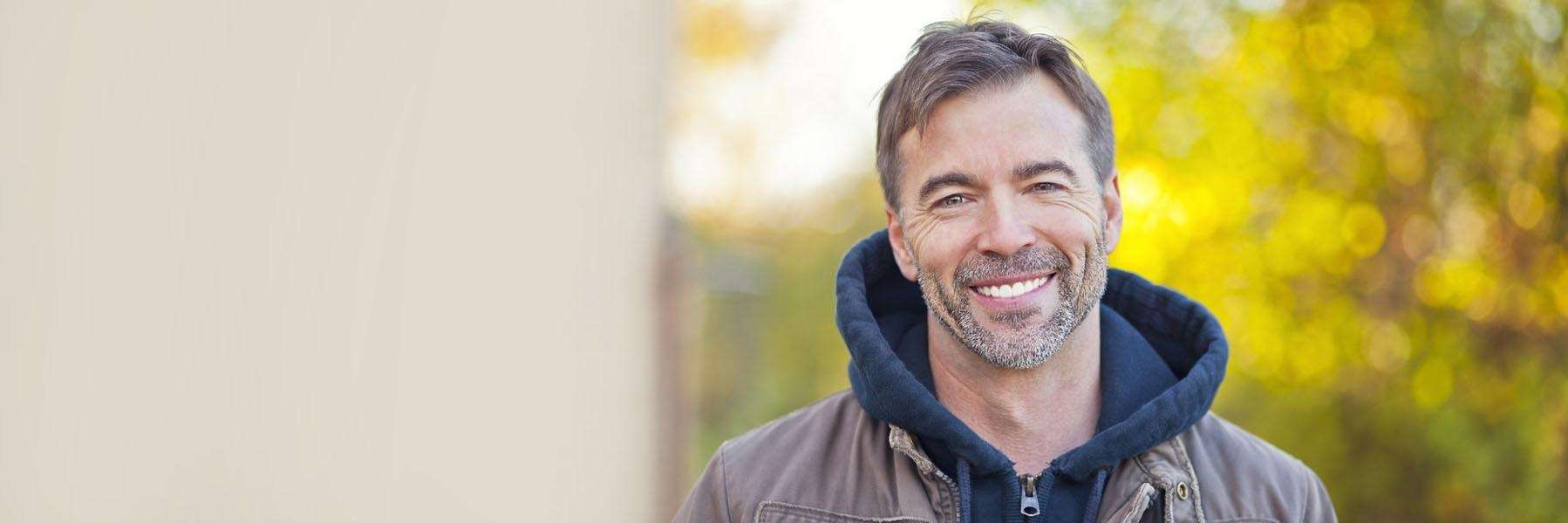 Man smiling after getting dental implants at Chesapeake Bay Dentistry